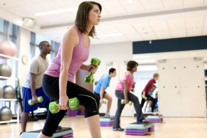 Mujer levantando pesas en un gimnasio.