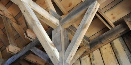 Image of a wooden post and beam construction with diagonal knee bracing supports for each beam.