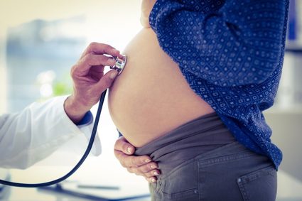 Ciąża w terminie porodu — osłuchiwanie tętna dziecka za pomocą stetoskopu.