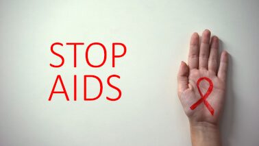 a STOP AIDS campaign poster, showing a hand with a red ribbon - sign of HIV/AIDS