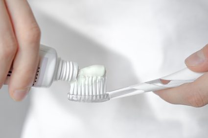Image of a toothpaste tube being squeezed to get toothpaste