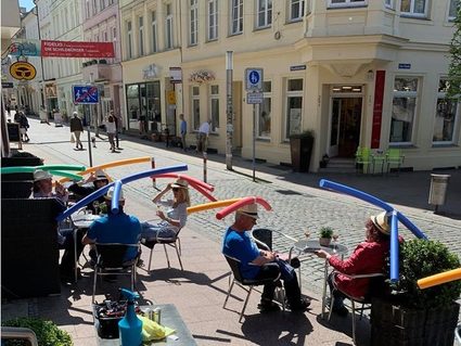 people practicing social distance in a cafe