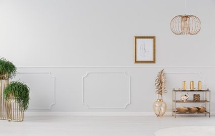 A white wall with wainscoting that gives character to the wall